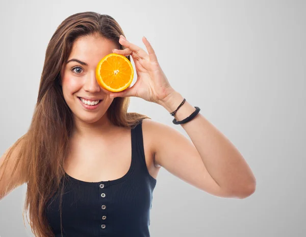Flicka som håller en orange skiva — Stockfoto