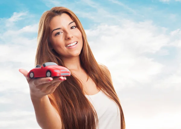 Mulher segurando um brinquedo de carro vermelho — Fotografia de Stock