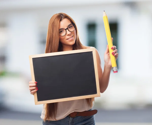 Estudiante sosteniendo una pizarra y un lápiz —  Fotos de Stock