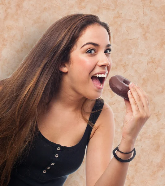 Mulher comendo um donut de chocolate — Fotografia de Stock
