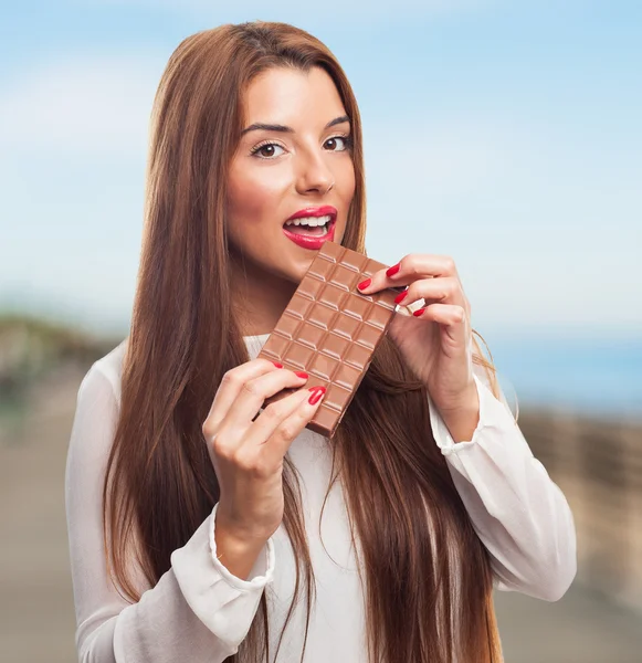 Bella ragazza che morde una barretta di cioccolato — Foto Stock