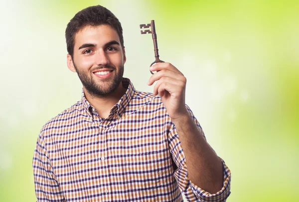 Man holding an old key — Stock Photo, Image