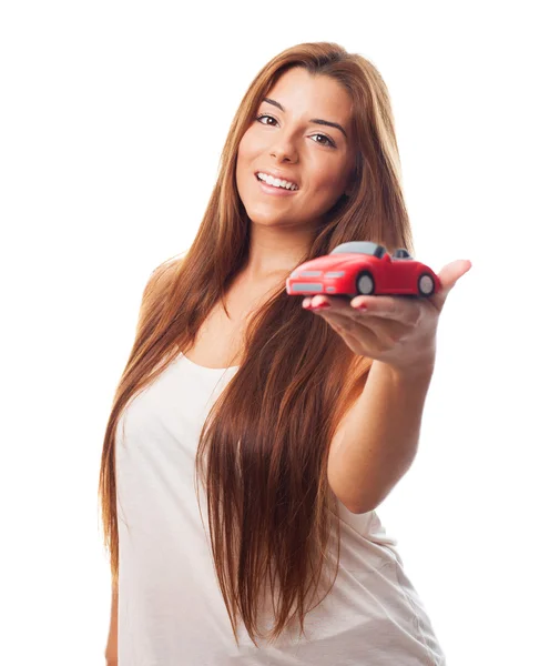 Mulher segurando um brinquedo de carro vermelho — Fotografia de Stock