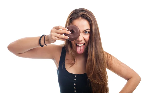 Vrouw op zoek via een chocolade donut — Stockfoto