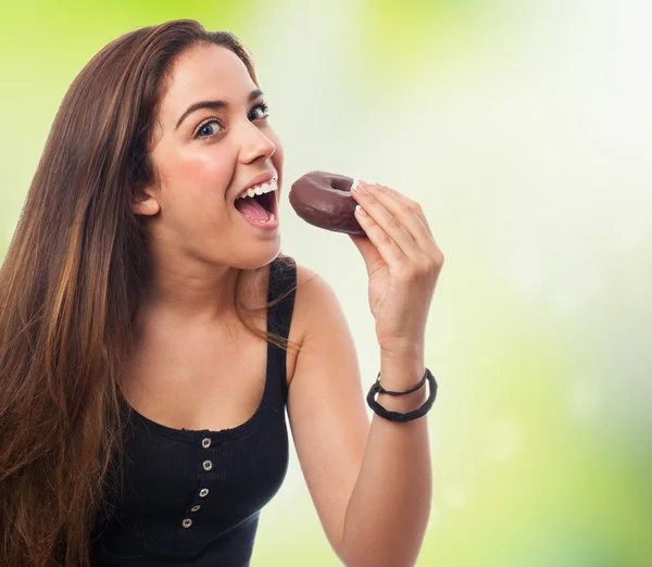 Donna che mangia una ciambella al cioccolato — Foto Stock