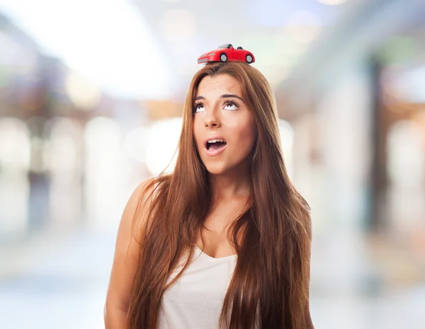 Woman with a red car over his head — Stock Photo, Image