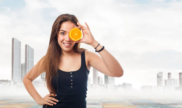 Chica sosteniendo una rebanada de naranja —  Fotos de Stock