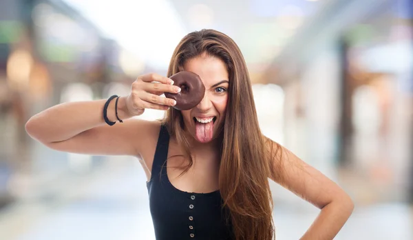 Donna che guarda attraverso una ciambella al cioccolato — Foto Stock