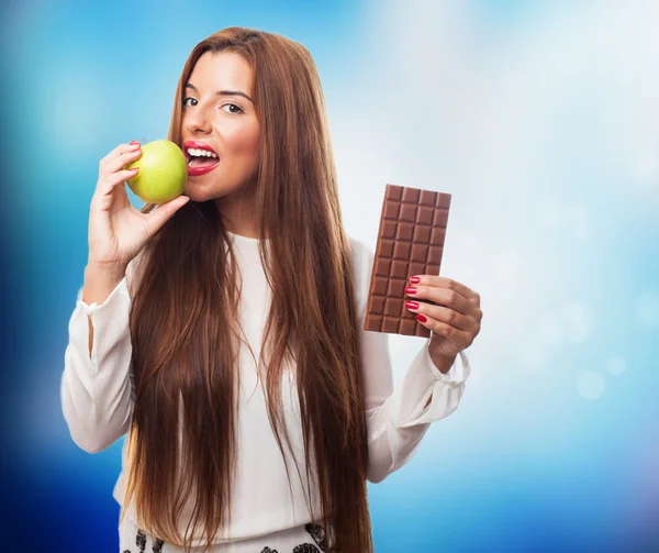 Vrouw eten een appel in plaats van een chocolade — Stockfoto