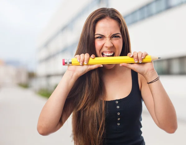 Vrouw bijten een grote potlood — Stockfoto