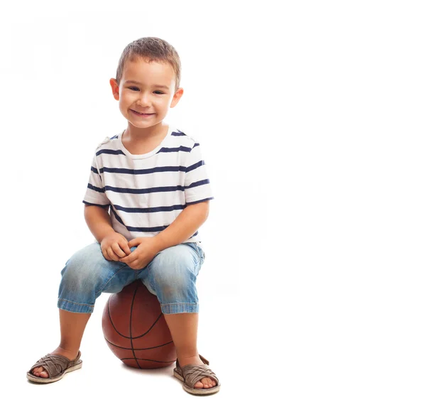 Boy sitting on a basketball — Stock Photo, Image