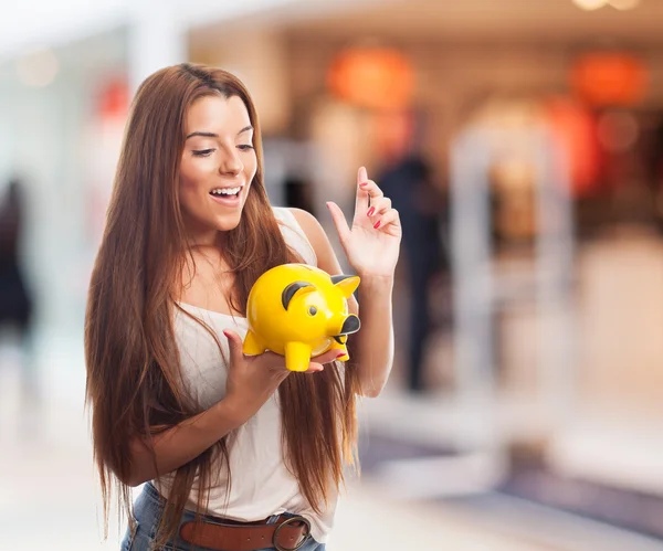 Mädchen steckt Münze in Sparschwein — Stockfoto