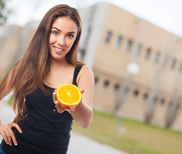 Frau hält Orangenscheibe in der Hand — Stockfoto