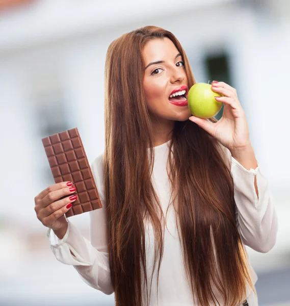 Vrouw eten een appel in plaats van een chocolade — Stockfoto