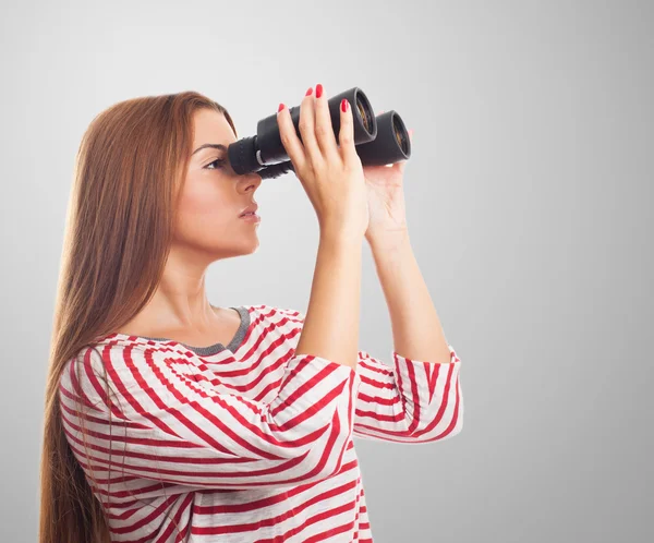 Woman looking through the binoculars — Stock Photo, Image