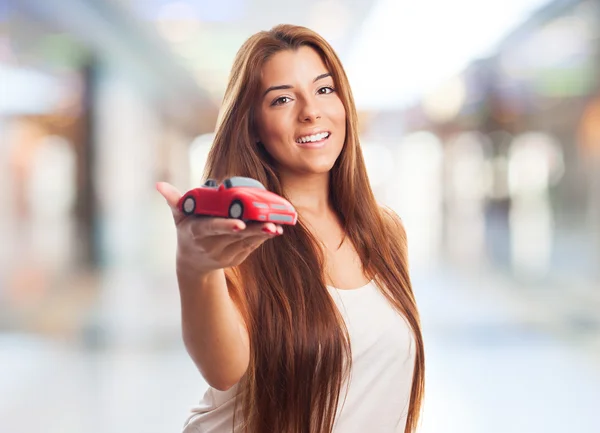 Mulher segurando um brinquedo de carro vermelho — Fotografia de Stock