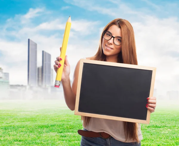 Student holding a chalkboard and a pencil — Stock Photo, Image