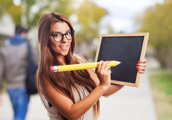Student s velkými tužku a chalckboard — Stock fotografie