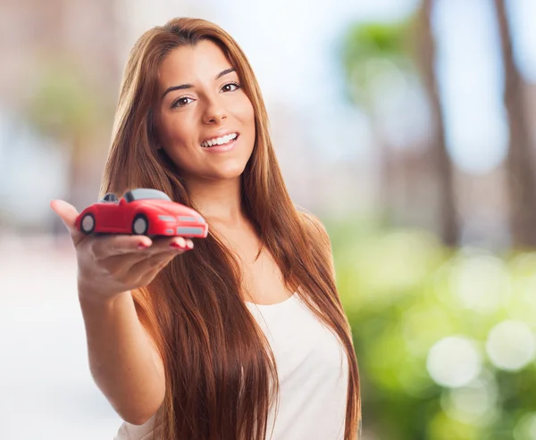 Woman holding a red car toy — Stock Photo, Image