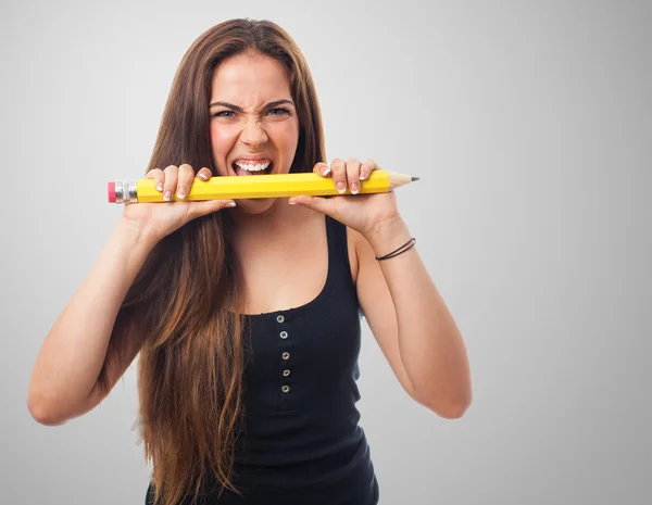 Vrouw bijten een grote potlood — Stockfoto