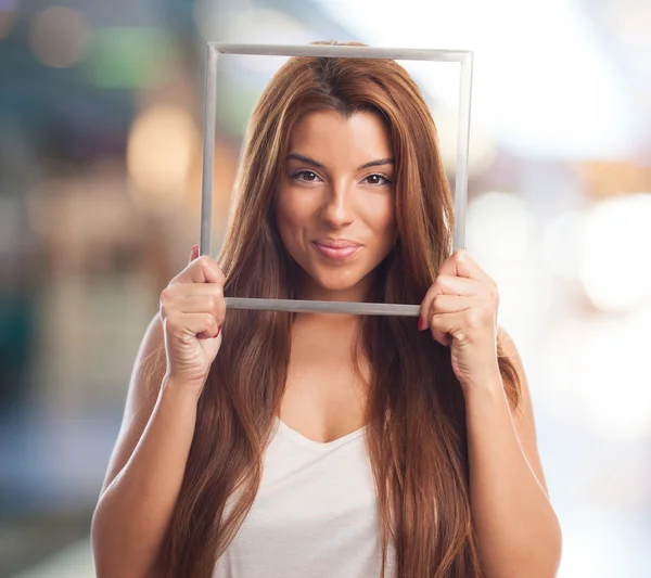 Mujer joven sosteniendo un marco — Foto de Stock