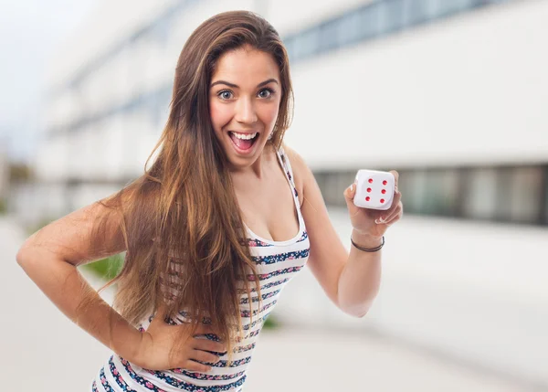 Jonge vrouw met een dobbelsteen — Stockfoto