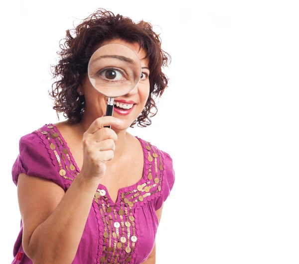 Woman looking through a magnifying glass — Stock Photo, Image
