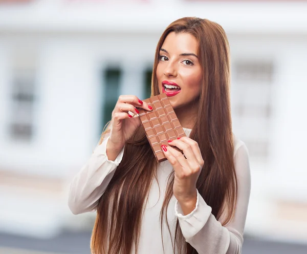 Hübsches Mädchen beißt in einen Schokoriegel — Stockfoto