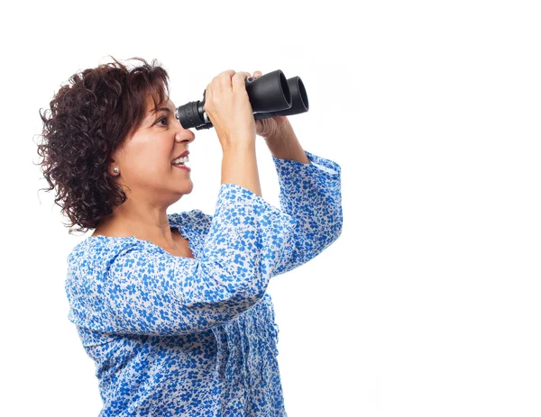 Woman looking through the binoculars — Stock Photo, Image