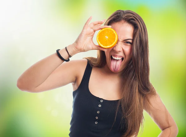 Mujer sosteniendo una rebanada de naranja bromeando —  Fotos de Stock