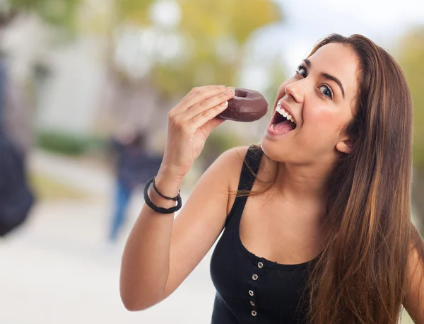 Nő eszik csokoládé fánk — Stock Fotó