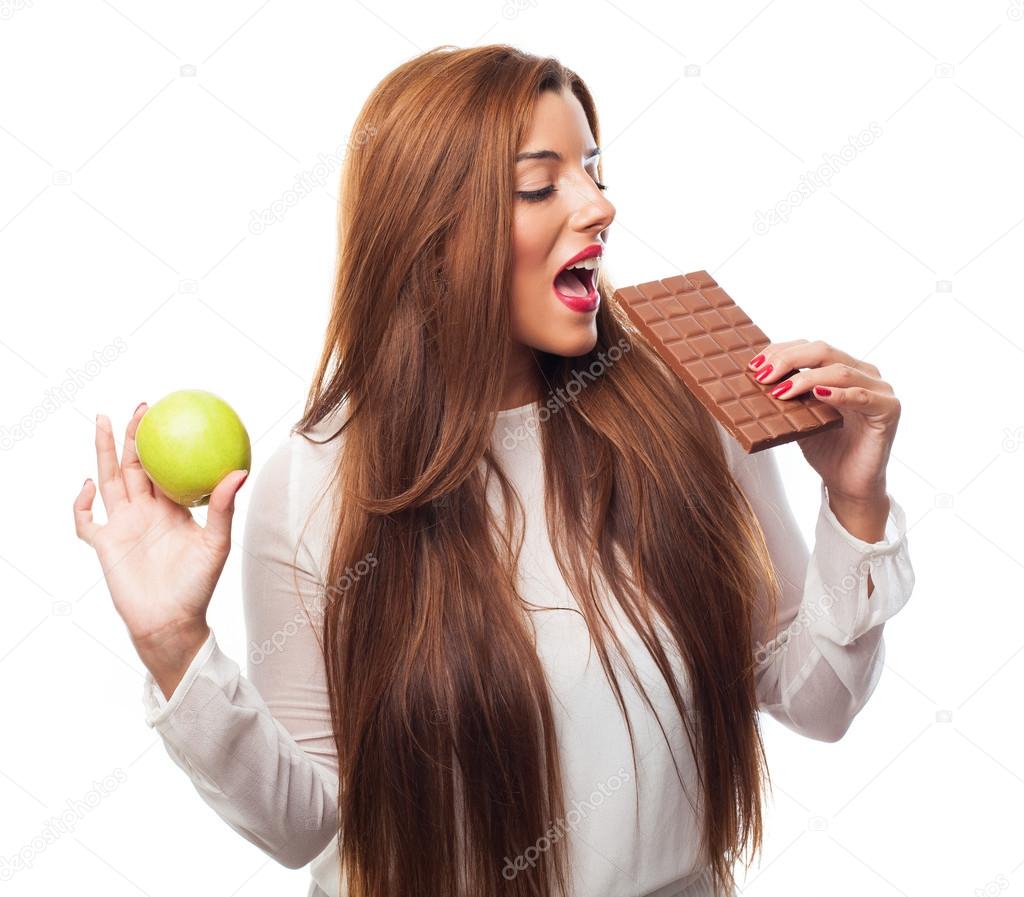 Girl choosing between apple or chocolate