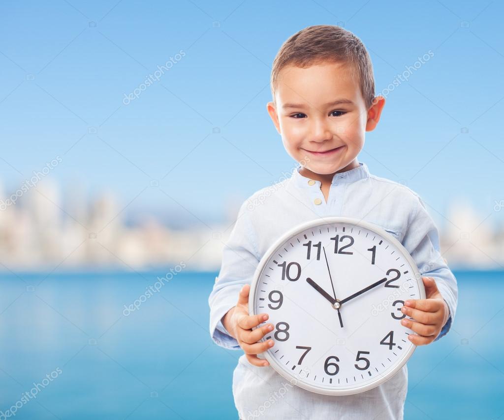 Little boy holding a clock