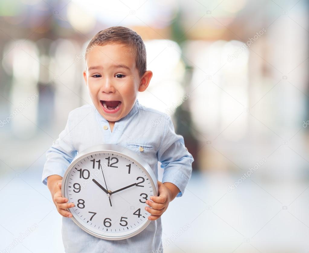 boy holding a clock