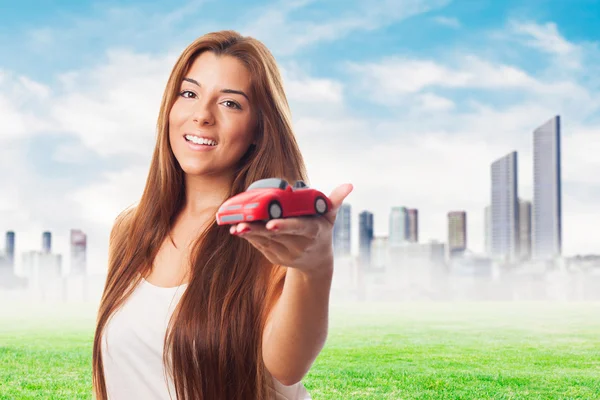 Mulher segurando um brinquedo de carro vermelho — Fotografia de Stock