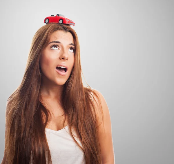 Woman with a red car over his head — Stock Photo, Image