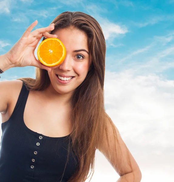 Chica sosteniendo una rebanada de naranja —  Fotos de Stock