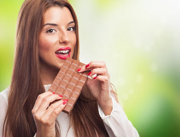 Pretty girl biting a chocolate bar — Stock Photo, Image