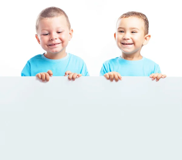 Kinder hinter einer Werbetafel — Stockfoto