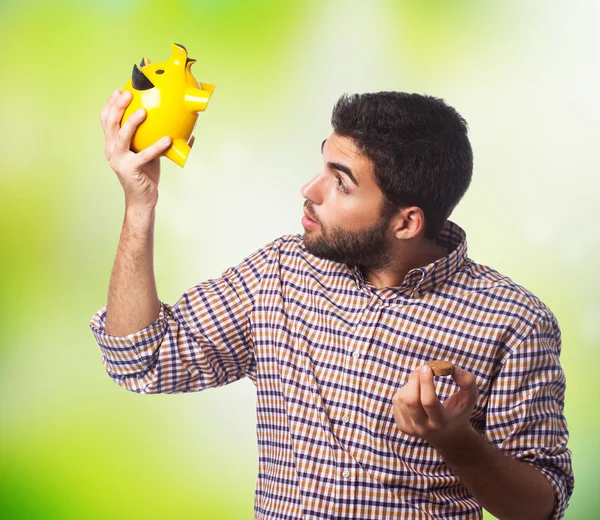 Man looking into a piggy bank — Stock Photo, Image