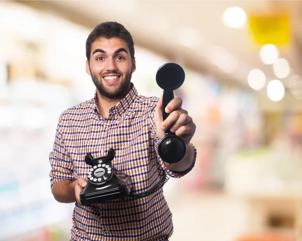 Joven ofreciendo teléfono —  Fotos de Stock