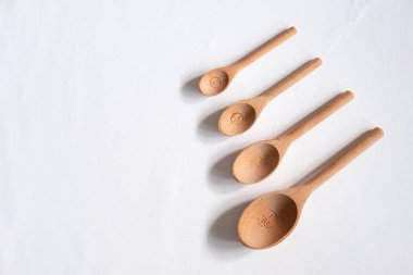 Kopyalama alanı olan beyaz arkaplandaki tahta ölçüm kaşıkları