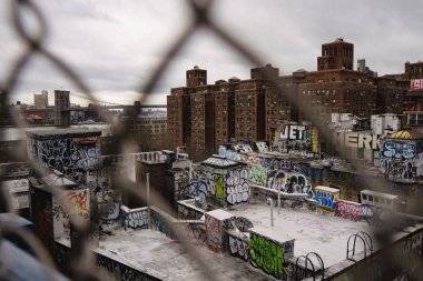 Grafiti kaplı çatıları ve binaları olan şehir manzarası.