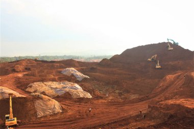 Ağır eksen kazıcıları kullanarak araziyi temizleyerek nikel madenciliği faaliyetini aç