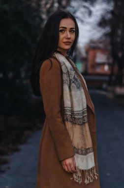 Sonbahar akşamında bir kız caddede yürüyor. Paltosunu ve atkısını giyiyor..