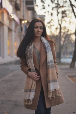 Genç kadın sonbahar şehrinde ceket ve bluzla poz veriyor.. 