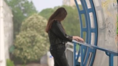 Depression thoughts. Girl is looking at the heavy rain near the train station glass.