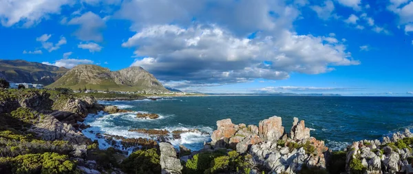 Sievers Point 'ten Walker Körfezi ve Klienrivier Dağları' nın kayalık kıyı şeridi manzarası. Hermanus, Balina Sahili, Overberg, Batı Burnu. Güney Afrika