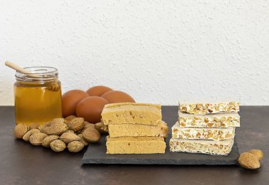 Turron, İspanya 'da tipik bir Noel tatlısıdır. Siyah taş tabakta içinde malzemeler olan bademli fındık.