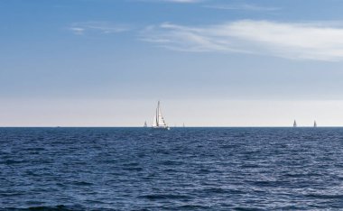 Akdeniz 'de yelkenli bir yatın silueti, arka planda mavi bir gökyüzü.. 